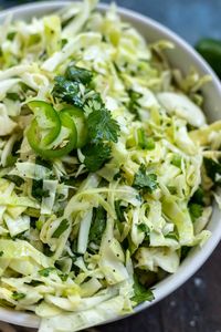 Cilantro Lime Slaw is a great summertime side dish or taco topping. Make this No Mayo Coleslaw with a few simple ingredients to serve at your next dinner or barbecue. #coleslawrecipe #cilantrolime #slaw #cilantrolimeslaw #sidedishrecipes