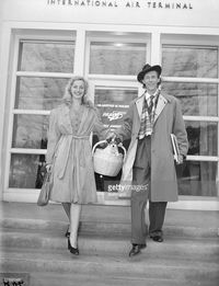 Shakespearean actor John Carradine and his wife, the former Sonia Sorel, at Lockheed Airport in Burbank, California, to begin a bond tour. Note Junior Carradine in the basket.