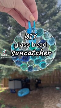 Difficulty: Easy  How cute is this suncatcher?! It is SO easy to make and the perfect activity for your toddler!  Supplies  • Plastic lid   • Clear glue  • Glass beads  • Ribbon  • Hot glue