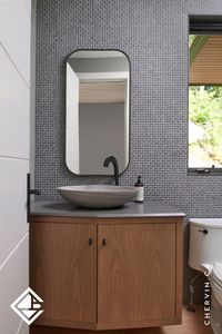 Discover inspiration in this angled white oak floating vanity, nestled within a fresh and modern cottage retreat. Its frame inset construction and sleek black hardware make it an impressive addition to the powder room, ensuring a stylish welcome for guests. ✨ Visit our website to view this project and for more inspirations! . . . #ChervinKitchen #CustomCabinetry #Handcrafted #CustomMillwork #InteriorDesign #BathroomDesign #CustomVanity