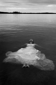 Bride floating in sea. Trash my dress