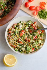 Serving a bowl of Costco quinoa salad with a lemon slice next to it.