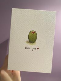 OLIVE YOU  is a a simple, minimalistic design with a dainty script, which will leave the recipient in no doubt about how you feel!  Spread some love to a family member, close friend or significant other with this cute design. Perfect for Valentine's Day, as well as Mother's Day, Father's Day or even 'Just Because'!  This is a high quality printed card, the paper used is Tintoretto Gesso. The 'hammered' texture of Tintoretto is strangely satisfying to touch! It has a luxurious feel and is easy to write on. The card comes accompanied with a brown 'Kraft' envelope. My logo and details are printed on the back. Paper size - A6 (148mm x 105mm) This is a print of my original watercolour illustration.