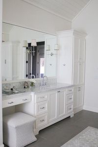 Master bathroom with Carrera marble countertops, Circa lighting sconces, and custom white cabinetry.