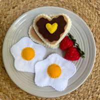 Handmade Felt Breakfast Set. This is a handmade beautiful and realistic felt set which would be perfect for your kid's play time. Each set includes  8 felt items.  SIZE: - Pancakes (2) 3.5 x 3.5" - Eggs (2) 3.75" x 3.5" - Strawberry (2)1.5" x 1.25" - Chocolate topping 2.25" x 2.5" - Slice of butter (heart-shaped) 1" x 1" Care: Hand wash in warm water and mild soap. Rinse and dry thoroughly. **Made in a Smoke Free and Pet Free Environment** Suitable for ages 3+