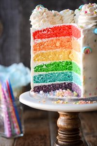 With fluffy vanilla buttercream flecked with sprinkles and Lucky Charms marshmallows, it’s so fun to cut the first slice and reveal the vivid rainbow cake layers hiding inside. This fun and colorful high altitude tested rainbow cake is perfect for birthday parties or St Patrick’s Day!