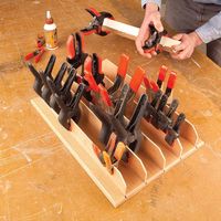 This tray is a nifty way to store spring clamps. It's a slotted piece of 3/4-in. plywood with 1/4-in. plywood fins glued in the slots. Store the tray on a peg and remove clamps when you need them. When you're done, stick the clamps back on the fins and hang up the tray.