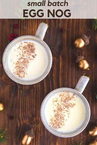 small batch of homemade eggnog in two mugs on wooden table