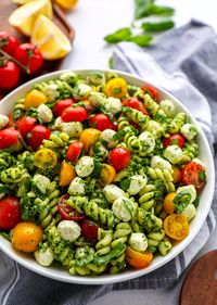 Savor the flavors of a refreshing pasta salad featuring pesto, juicy tomatoes, and creamy mozzarella, inspired by Kalefornia Kravings.