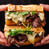 The best steak sandwich combines toasty baguette piled with tender skirt steak, caramelized onions, melty provolone cheese, baby arugula, and the easiest chipotle mayo.