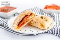 This Homemade Calzone Recipe is so fun to make with your family. An easy dough and sauce combined with lots of gooey cheese and favorite pizza toppings make this a simple supper everyone will be happy to help prepare! #calzone #calzones #quickandeasycalzones #easycalzones #Italian #EasyRecipe #ItalianFood #Recipe #FavoriteRecipe #FavoriteFamilyRecipes