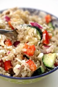 Instant Pot Greek Chicken Rice Bowls--brown rice and chicken are tossed with a lemon juice, olive oil, fresh garlic and vinegar dressing. Diced cucumber, red bell pepper, red onion and feta cheese are stirred into the rice to complete the one pot meal.