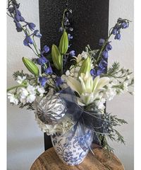 Granbury Florist original design that brings a non-traditional mix of white and blue floral blooms with cedar accents in a vintage style print vase. The perfect mix for a holiday treat!