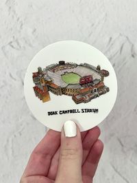 "Florida State University Doak Campbell Stadium Sticker / FSU Computer Sticker / Florida State University sticker / FSU Football Art Florida State University Doak Campbell Stadium watercolor art Sticker is a sticker of a my hand drawn, watercolor painting. It features the iconic football stadium at FSU. Go Noles! artxnikki is a licensed Florida State University artist- The University names and logos on this product are registered trademarks of Florida State University. 3\"x3\" vinyl waterproof s