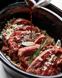 slow cooker rosemary & garlic balsamic lamb sandwiches. a majorly delicious & majorly easy lamb slow cooker recipe. lamb shoulder slowly simmers away with tons of garlic, fresh rosemary, & balsamic vinegar, then gets shredded for the best slow cooker lamb sandwiches. an easy & delicious recipe for any fall potluck, football get-together, or holiday party this season! #plasywellwithbutter #slowcookerrecipes #crockpotmeals #lambrecipes #lambshoulder #easylambrecipe #lambsandwich