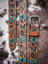 Sundown Hooey Embossed Belt This Hooey embossed men's belt features tan leather detailed with Actec filigree with Turquoise painted accents. Genuine leather Straight Embossed Sliver-Plated Buckle HMBLT067 Men's Size Scale : Straight: 1.5" wide (38mm) Tapered: 1.75" to 1.5" wide Designer size recommendations : - measure the waist or take your jean size and go up one size. Tongue Buckles: sized from buckle end to center hole. **Since leather is a natural organic material and each piece is essentially one of a kind, please allow for slight leather color variations.