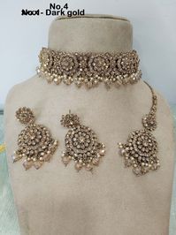 *Light weight gold choker necklace Set with earrings Tikka as shown in the pic.  * Studded with crystals and rhinestones.  * One of a Kind. *Necklace Width- 1.5 inches(included drops) * Earrings Length: 2.8 inches(included drops) *Earrings width- 1.2 inches