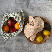 "With a traditional Japanese Azuma Bukuro design, our 'Tanuka' bento bag has been made with indigenous 'Kala' cotton. We like to call them 'an anyting bag'. Use them for storing veggies and fruits, as a project or gift bag, as a travel organizer or to carry your lunch box! Pair them with our travel cutlery wrap for a waste free lunch. 'Kala' cotton is an old world indigenous cotton variety from Kachchh, Gujarat, India and is by nature sustainable and organic, being cultivated without the use of