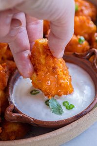 Looking for a vegan friendly Super Bowl snack that everyone will love? These easy Vegan Buffalo Tofu Wings are so delicious and packed with flavor! You can make this recipe using tofu or cauliflower and it turns out perfect every time. Serve with a side of ranch or blue cheese dressing and veggies. #veganwings #buffalotofu #plantbased #vegetarian #vegan #appetizer #gamedayrecipe