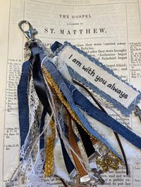 "I am always with you"...(even unto the end of the world ) is a beautiful scripture taken from the Book of Matthew 28: 20.  It is a powerful reminder that no matter how bad the circumstances, He is there to take your yoke and comfort you forever.  The tassel is made up of recycled denim, sari ribbon, lace, trim, silk ribbon, several cross charms and suede.  It is hand crafted and designed by me.