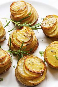 Oven baked potato stacks with herbs, ready to be eaten.