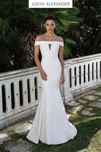 This crepe off the shoulder fit and flare wedding gown features an illusion cut out at the bust adding a subtle hint of today's modern styling. For a more conservative look, the gown also available without the cut out.