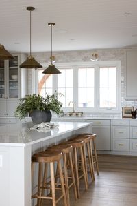 Find your kitchen inspo in our Willow Creek Kitchen Project! A neutral kitchen with a large textured range hood, beautiful zellige tile backsplash, and brass pendant lights.