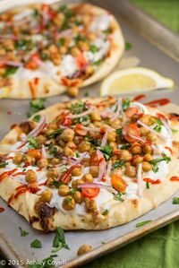 Naan is covered in garlicky tzatziki sauce and covered with Middle Eastern-spiced chickpeas, tahini, fresh herbs and Sriracha in this street food/comfort food mashup.