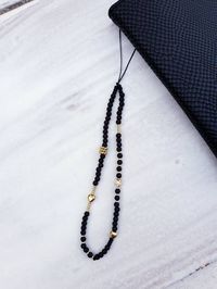 Trendy cute black and gold beaded phone charm :) Doesn't this cute charm just make you happy! I made this one with various beads made of different materials like glass, wood, acryl, polymer etc. Each one is one of a kind, no phone charm is exactly the same, so unique it is! Great gift as well! Very easy to attach to your phone case, shoulder bag, keychain etc. -------------------------------------------- PLEASE READ BEFORE ORDERING -------------------------------------------- ★ These phone charm