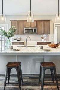 This gorgeous kitchen from @mylandmarkhome is the epitome of modern minimalism. Our Clarion pendants above the island feature clear glass shades and simple black hardware, offering a barely-there aesthetic and ideal task lighting. Shop Clarion at the link: 📷: @landmarkhomes on IG