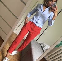 Pantalón tipo formal corto color naranja y blusa tipo camisa azul de botones, tenis blancos