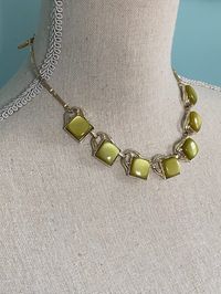 Dating from the 1950s/60s, this set would nonetheless look great with a contemporary casual or dressy outfit. The olive green thermoplastic against pale gold tone metal has a cool vibe, and the necklace can be worn with or without the earrings, depending on the desire to achieve a matchy-matchy or more relaxed look. Unsigned, this jewelry is in keeping in style and quality with, amongst others, Coro, Lisner or Star thermoplastic jewelry of the period. A timeless demi-parure. Necklace extends to 16" L. Earrings measure 7/8" H x 3/4" W. In excellent vintage condition.