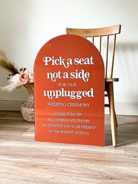 "Acrylic Pick a Seat Arch Unplugged Ceremony Sign | Arch Unplugged Ceremony Sign | Pick A Seat Not A Side Sign ♥DESCRIPTION♥ * Lettering comes engraved or uv printed (depending on the color selected) * Stand or Flowers NOT included * Thickness: 1/8\" acrylic.  * Choose your background color. Matching welcome sign: https://www.etsy.com/listing/1253710837/modern-arch-acrylic-welcome-sign?click_key=65095e5cda93a8fca240811c62bd880af9e752ba%3A1253710837&click_sum=db306fe4&ref=shop_home_active_65&pro=1&frs=1 Matching table numbers:  https://www.etsy.com/listing/1250792360/arch-painted-back-acrylic-table-numbers?click_key=ecf81486b266c56e4ddbeba6b47b29f9ddc3911e%3A1250792360&click_sum=7b681692&ref=shop_home_active_21 Copyright © Blush and Lumber 2011"