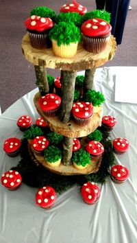 Woodland moss & red mushroom cupcakes on a rustic wooden cupcake stand #Camping #Birthday. Love that some are chocolate and some vanilla both with plain wrappers - adds even more contrast.