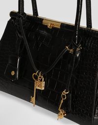 Crocodile-print calfskin Marlene handbag: Black Crocodile-print calfskin handles Gold-plated metal turn-lock fastening Nappa leather lining Item comes with a branded dust bag Measurements: H20.5 x W30 x D12 cm Made in Italy