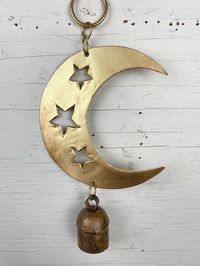 "BRIGHT GOLD CRESCENT MOON WIND CHIME WITH THREE CUT OUT STARS AND RUSTIC BELL - LARGE AND SMALL The moon and the stars come together to create this beautiful chime. Add a mix of modern and rustic décor to your home with this hanging moon. This chime would look perfect outside in your garden, or on your deck or porch to spin with the wind. It also looks great inside to hang from a ceiling or wall. It would suit a nursery particularly well. We have two options - a large chime, and a smaller chime