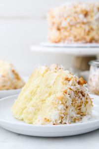 This Coconut Custard Cake is a vanilla cake flavored with coconut and layered with a decadent creamy coconut custard and frosted with cream cheese frosting. Cover this cake with shredded coconut for the ultimate coconut cake. #coconutcake #coconutcakerecipe #coconutcakefrosting