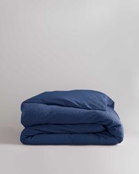 Our beautifully textured waffle duvet cover is woven from super soft 100% organic cotton. Lightweight and breathable, it features a traditional honeycomb design on the front and a classic 400 thread count percale on the reverse side. Handcrafted for aesthetic ease and touchable comfort. Organic cotton is made without harmful toxins like pesticides or insecticides, making it safer for the farmers who harvest it, the consumers who use it, and the environment.