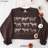 "This Unisex crewneck sweatshirt features \"support your local farmer.\" with a vintage set of cow illustrations. It is the perfect gift for cattle ranchers, cow lovers, homesteaders and more! Make sure to check out the other garment options below :) » O P T I O N S « ‣ Tshirt: https://www.etsy.com/listing/1484256374 » A B O U T « ‣ This item is made to order using direct-to-garment (DTG) printing technology. This digital process involves the printer inks being jetted or sprayed onto the textile by a print head after the garment goes through a pre-treatment machine to create a stronger bond between garment fibers and the pigmented inks. ‣ This is NOT screen printed NOR do we use heat transfer vinyl (iron-on). » S I Z I N G « ‣ Since we all have different bodies, some find the garments to b