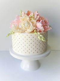 Gold polka dot cake with fondant flowers on top by The Cake That Ate Paris (via Hello May).