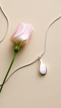 A tear-shaped pendant in recycled sterling silver on a snake chain.