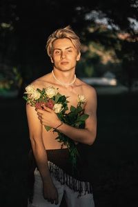 A man in a hula skirt holding a bouquet of flowers photo – Free Portrait Image on Unsplash