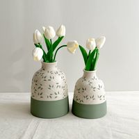 Enhance your home decor with our unique handmade ceramic vases. These elegant bottle-shaped vases feature beautiful green hues and intricate leaf engravings, making them both a perfect gift option and ideal for displaying dried flowers. Available as a 2-piece set (large and small) or individually, each vase is meticulously crafted to stand out as a unique piece.  DIMENSIONS: Large: ↕ Height: 18-19 cm. / 7.08 - 7.48 in.  Ø Diameter: 4 cm. / 1.57 in.  Small: ↕ Height: 15-16 cm. / 5.90 - 6.29 in. Ø