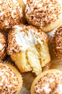 These Coconut Cream Pie Cupcakes feature light, moist and airy coconut cupcakes filled with coconut custard, topped with creamy coconut frosting and dipped in toasted coconut. Coconut Lovers, meet your new addiction! | queensleeappetit.com #coconut #coconutcake #cupcakes #dessert