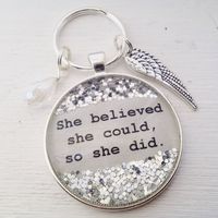 "She believed she could so she did sparkle keychain, silver finish. Keychain round is 1.5\" Sparkles are stationary where they are pictured."