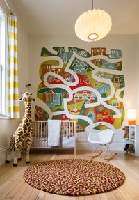 Minimalist nursery wit a large colorful mural by Brian Barneclo.