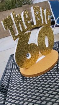 Glittered gold party centerpiece for The BIG 60. Centerpiece stand painted metallic gold. Only from https://designcutters.etsy.com