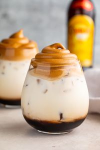 What's better than fluffy, sweet whipped coffee over milk? Boozy whipped coffee, of course! This easy cocktail pairs coffee liqueur with milk, all topped with a little cloud of whipped coffee for an Instagram-worthy drink. Perfect for brunch or after dinner, and easy to make vegan. #dalgonacoffee #whippedcoffee #whiterussian #alcohol