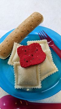 This is a wonderful set of ravioli pasta with sauce and bread sticks for two to enjoy. This set will make a great addition to any child's play kitchen. This set is made for hours of open ended play. To be loved for years to come. Everyone loves pasta, let's get cooking! This set includes 8 ravioli pasta 2 felt red sauces with tiny seasoning sewn in for that additional touch. 2 felt bread sticks with seasoning sewn in. This set includes only what is listed above. As always I never use glue or pai