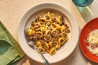 Tender veal ragù is flavored with white wine, capers, thyme, and rosemary, then tossed with the little ear-shaped orecchiette pasta.